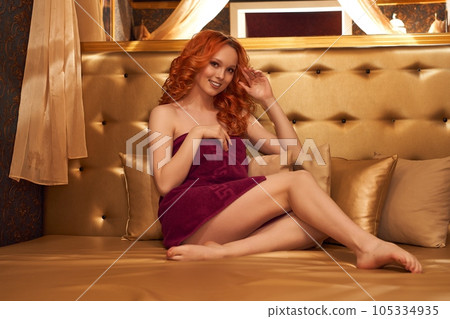 Chic woman laying in gold room in a towel Chic woman laying in gold room in a towel 105334935