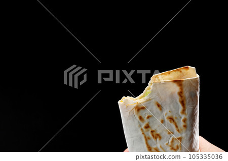 bit off a pita bread, fajitas, burrito, shawarma on a white background bit off a pita bread, fajitas, burrito, shawarma on a white background 105335036