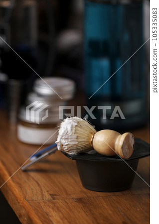 Set of shaving equipment and men's cosmetic products on wooden table, barbershop. shave concept with a straight razor, shaving brush and foam. beard care products for men on background. 105335083