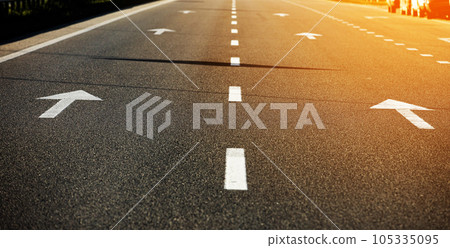 Asphalt highway with road markings. Road and orange sunlight background. 105335095