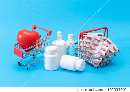 Pills and Capsules in Shopping Cart on Blue Background 105335701