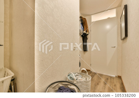 a laundry room with clothes hanging on the wall and an open door that leads to a washer in the corner 105338200