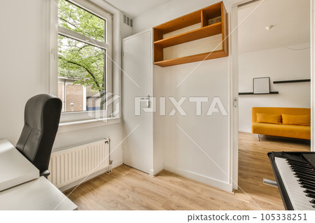 a small room with a piano in the corner and an open door leading to another room on the other side a small room with a piano in the corner and an open door leading to another room on the other side 105338251