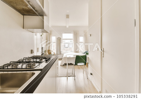 a kitchen and dining area in a house with white walls, wood flooring and stainless appliances on the wall 105338291