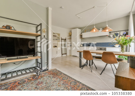 a living room with a tv on the wall and an area rug that has been used as a dining table a living room with a tv on the wall and an area rug that has been used as a dining table 105338380