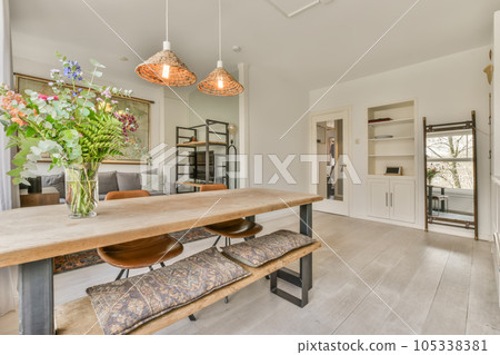 a dining room with wooden table and bench in the middle part of the room, there is an open kitchen area 105338381