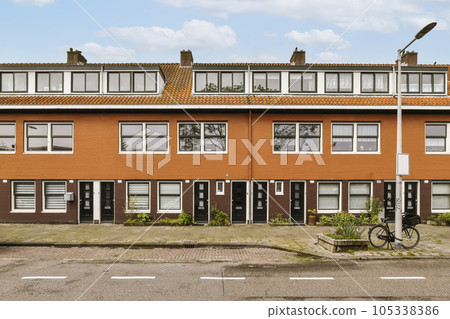 an apartment complex in the netherlands, with a bicycle parked on the street next to it and two story brick buildings 105338386