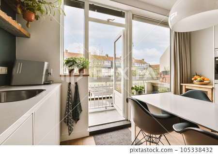a kitchen and dining area in a small apartment with sliding glass doors leading out onto the terraced courtyards a kitchen and dining area in a small apartment with sliding glass doors leading out onto the terraced courtyards 105338432