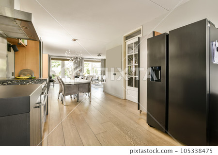 a kitchen and dining area in a house with wood floors, white walls, black refrigerator freezer and wooden floor 105338475
