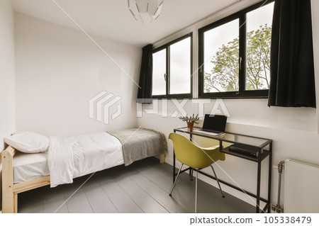 a bedroom with a bed, desk and window overlooking the cityscapearn com logo on the wall 105338479
