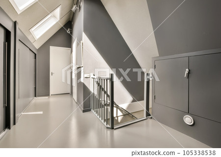 a hallway in an office building with stairs leading up to the second floor and skylights on the upper level a hallway in an office building with stairs leading up to the second floor and skylights on the upper level 105338538