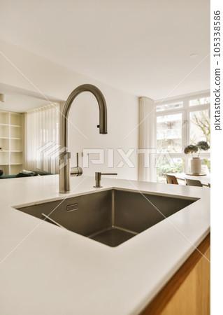a kitchen with white counter tops and wood cabinets in the background, there is an open window to the outside 105338586