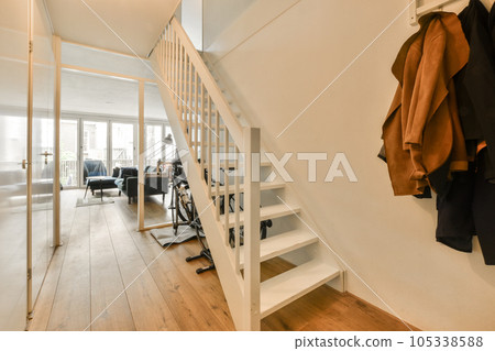 the inside of a house with clothes hanging on the wall and stairs leading up to the second floor in an apartment 105338588