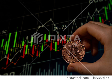 Female hand holding Bitcoin gold coin on background of Stock Market Chart. Bitcoin mining trading concept. BTC golden money. Worldwide virtual internet Cryptocurrency or crypto digital payment system Female hand holding Bitcoin gold coin on background of Stock Market Chart. Bitcoin mining trading concept. BTC golden money. Worldwide virtual internet Cryptocurrency or crypto digital payment system 105339153