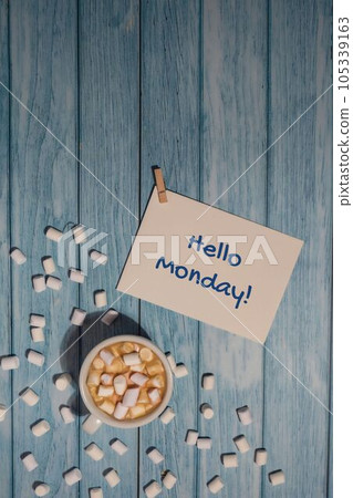 HELLO MONDAY blue monday concept text paper note with white cup of coffee and marshmallows on wooden background. The most depressing day of the year in January. Day commit suicide and depression HELLO MONDAY blue monday concept text paper note with white cup of coffee and marshmallows on wooden background. The most depressing day of the year in January. Day commit suicide and depression 105339163