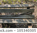 A decaying wooden bench and sunlight filtering through the trees in summer 105340305