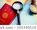 A passport, a magnifying glass and a wristwatch placed on a world map 105340510
