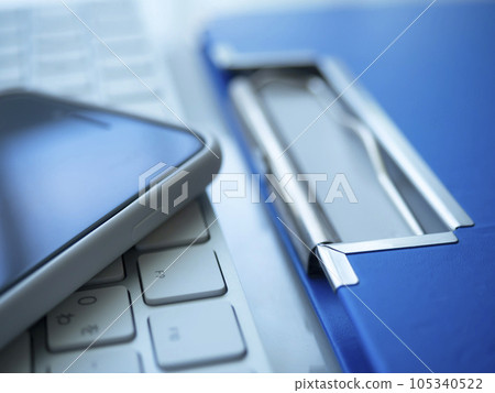Binders, keyboards and smartphones on the table Binders, keyboards and smartphones on the table 105340522
