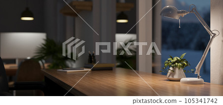 Copy space on a wooden table against the window with a table lamp in a modern dark office room Copy space on a wooden table against the window with a table lamp in a modern dark office room 105341742