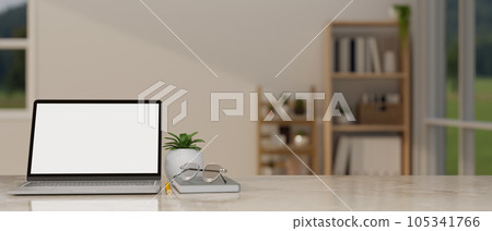 A laptop mockup on a tabletop in a minimal cozy living room. workspace close-up image. 105341766
