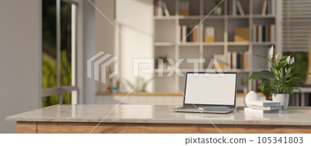 A laptop mockup on a tabletop over blurred background of a modern room with large bookshelves. A laptop mockup on a tabletop over blurred background of a modern room with large bookshelves. 105341803