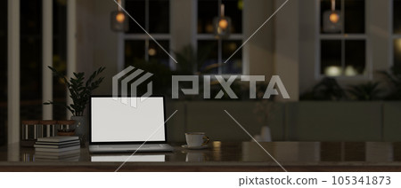 A laptop white screen mockup on a tabletop in modern comfortable room at night. A laptop white screen mockup on a tabletop in modern comfortable room at night. 105341873