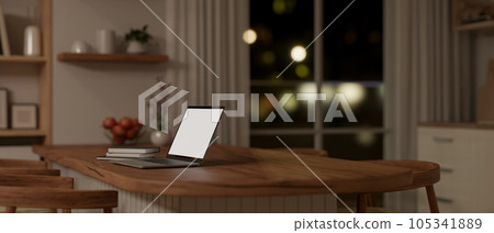 Rear view of a laptop mockup on a wooden dining table in a minimal kitchen at night. Rear view of a laptop mockup on a wooden dining table in a minimal kitchen at night. 105341889