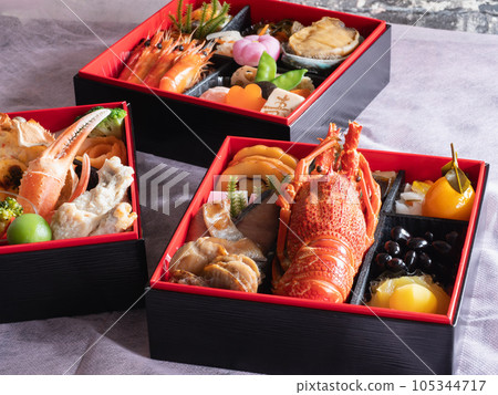 Japanese New Year dishes. Traditional New Year's dish. A three-tiered jubako containing Datemaki, Kurikinton, spiny lobster, and abalone. 105344717