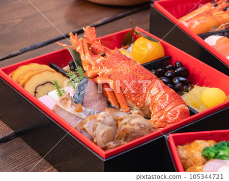 Japanese New Year dishes. Traditional New Year's dish. A multi-tiered box containing Datemaki, Kurikinton, spiny lobster and abalone. Japanese New Year dishes. Traditional New Year's dish. A multi-tiered box containing Datemaki, Kurikinton, spiny lobster and abalone. 105344721