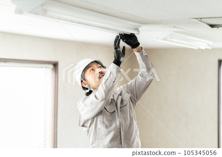 檢查熒光燈具的男工人 105345056