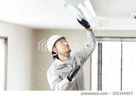 檢查熒光燈具的男工人 105345057