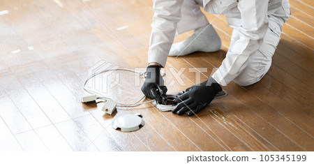Male worker inspecting underfloor wiring Male worker inspecting underfloor wiring 105345199