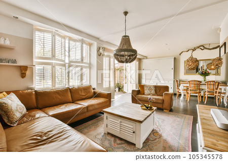 a living room with couches, coffee table and television set in the center of the photo is taken from inside 105345578