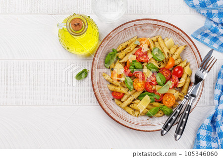 Italian pasta adorned with fresh tomatoes and aromatic basil 105346060