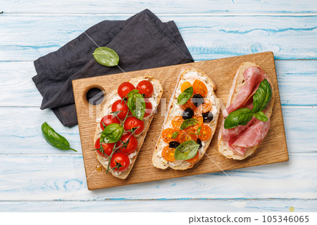 Sandwich set of bruschetta with juicy tomatoes, cheese and prosciutto Sandwich set of bruschetta with juicy tomatoes, cheese and prosciutto 105346065
