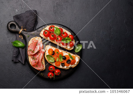 Sandwich set of bruschetta with juicy tomatoes, cheese and prosciutto 105346067