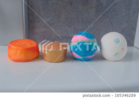 Four colorful bath salts and bath bombs that can be put in a bath with a cylindrical, trapezoidal or round shape Four colorful bath salts and bath bombs that can be put in a bath with a cylindrical, trapezoidal or round shape 105346289