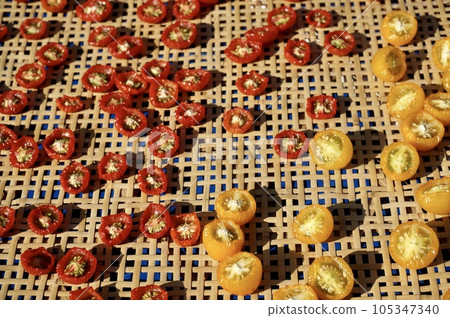 Sundried tomatoes drying on a bamboo colander Sundried tomatoes drying on a bamboo colander 105347340