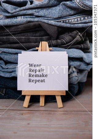 WEAR REPAIR REMAKE REPEAT text on paper note on Jeans clothes assortment Second hand sustainable shopping. Capsule minimal wardrobe. Sustainable fashion overconsumption, conscious buying consumption WEAR REPAIR REMAKE REPEAT text on paper note on Jeans clothes assortment Second hand sustainable shopping. Capsule minimal wardrobe. Sustainable fashion overconsumption, conscious buying consumption 105347371