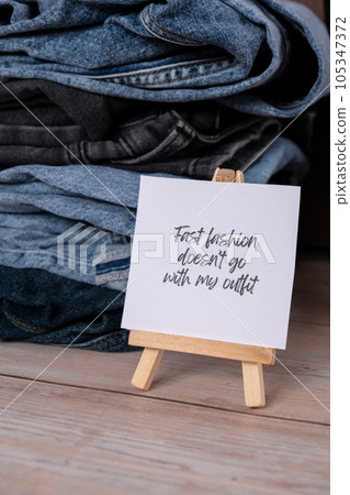 FAST FASHION DOESNT GO WITH MY OUTFIT text on paper note on Jeans clothes assortment Second hand sustainable shopping. Capsule minimal wardrobe. Sustainable fashion overconsumption, conscious buying 105347372