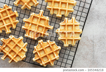 Freshly baked waffles on a baking rack. Freshly baked waffles on a baking rack. 105348218