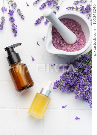 Lavender salt, natural essential oil and fresh lavender on a white tile background 105348240