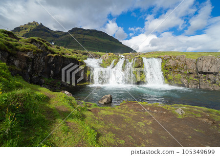 Kirkjufell mountain and river in Iceland in summer season. Famous landscape nature background at sunset 105349699