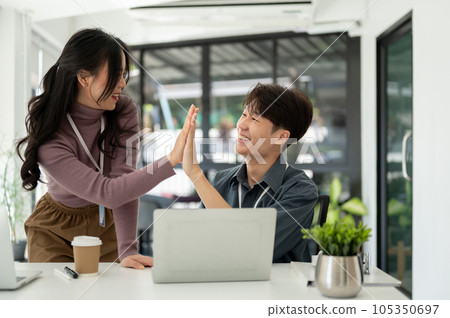 Cheerful Asian business people give high fives to each other to celebrate their successful project Cheerful Asian business people give high fives to each other to celebrate their successful project 105350697