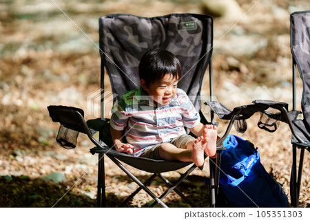3 year old boy sitting on an outdoor chair 105351303