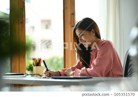 Attractive asian woman entrepreneur writing notes or planning workday in personal daily planner 105351570