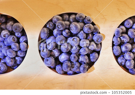 Tasty bilberry on wooden plate 105352005