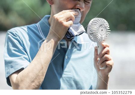 Image of intense heat Man wiping sweat Handy fan Body parts Image of intense heat Man wiping sweat Handy fan Body parts 105352279