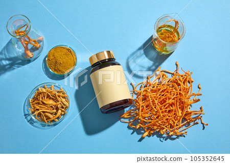 An empty label medicine bottle decorated with a pile of Cordyceps and some laboratory glassware. Antioxidant content in Cordyceps may explain their anti-aging potential An empty label medicine bottle decorated with a pile of Cordyceps and some laboratory glassware. Antioxidant content in Cordyceps may explain their anti-aging potential 105352645