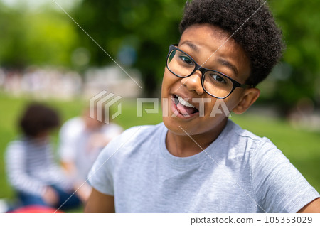 Smiling curly-haired african american teen looking happy Smiling curly-haired african american teen looking happy 105353029